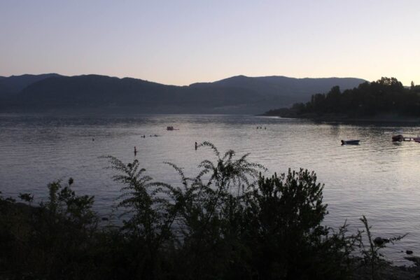 Atardecer en el Lago Calafquén, con personas disfrutando del agua en la Región de la Araucanía, sur de Chile