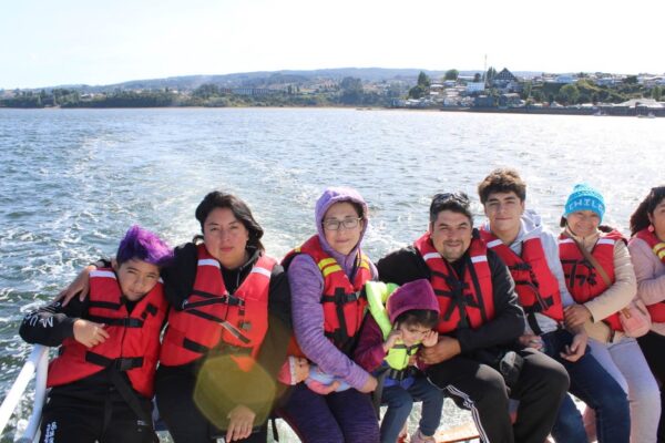 Familia disfrutando de paseo en bote por lago del sur de Chile durante el tour Sur de Chile Esencial