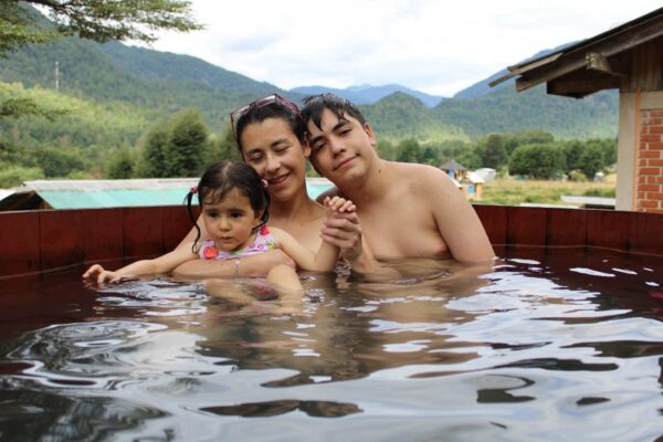 Familia relajándose en termas de Liquiñe, rodeados de naturaleza en el sur de Chile